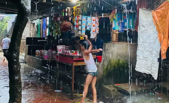 A child plays in heavy rain at a Rohingya refugee camp in Cox's Bazar, Bangladesh, Tuesday, July 7, 2026. (AP Photo/Shamimul Islam Faisal)