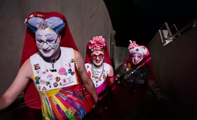 From left, Sister Pia, Sister Clementia and Sister Daphne of the German chapter OSPI of the Sisters of Perpetual Indulgence, SPI, arrive at a train station for the first Berlin Drag March on the eve of the Pride March in Berlin, Germany, Friday, July 24, 2026. (AP Photo/Markus Schreiber)
