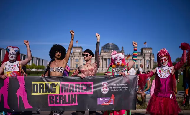 Sister Pia, left, Sister Daphne, second right, and Sister Clementia of the German chapter OSPI of the Sisters of Perpetual Indulgence, SPI, pose in front of the German parliament building the Reichstag Building during the first Drag March on the eve of the Pride Parade in Berlin, Germany, Friday, July 24, 2026. (AP Photo/Markus Schreiber)