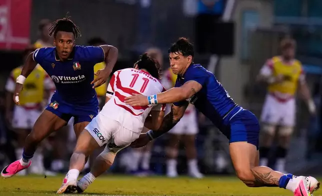 Italy's Tommaso Menoncello, right, with his teammate Malik Faissal, left, tackle Japan's Kippei Ishida during the Nations Championship rugby match between Japan and Italy in Tokyo, Saturday, July 4, 2026. (AP Photo/Shuji Kajiyama)