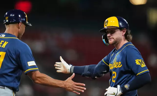 Milwaukee Brewers' Brice Turang (2) is congratulated by first base coach Spencer Allen after hitting a two-run single during the seventh inning of a baseball game against the St. Louis Cardinals Monday, July 6, 2026, in St. Louis. (AP Photo/Jeff Roberson)