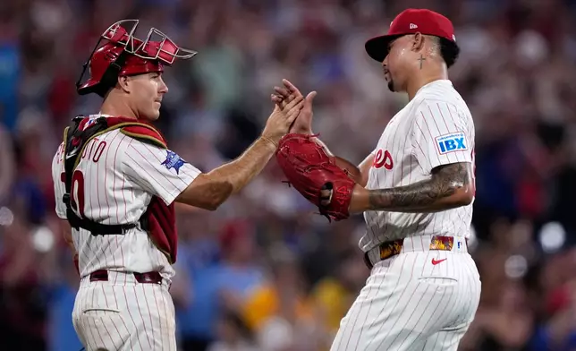Philadelphia Phillies' J.T. Realmuto, left, and Jhoan Duran celebrate after the Phillies won a baseball game against the Pittsburgh Pirates Wednesday, July 1, 2026, in Philadelphia. (AP Photo/Matt Slocum)