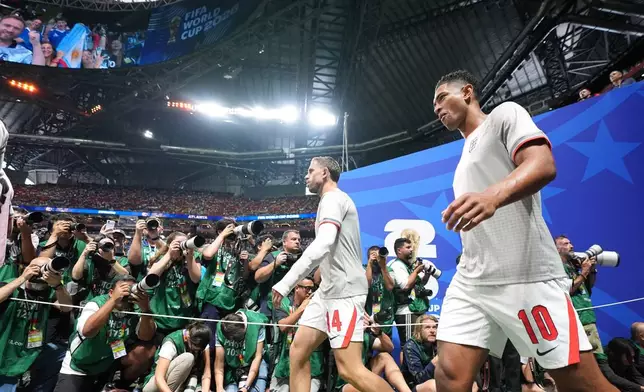 England's Jude Bellingham and Jordan Henderson, left, walk on to the pitch for the warmup before the World Cup semifinal soccer match between England and Argentina in Atlanta, Wednesday, July 15, 2026. (AP Photo/Rebecca Blackwell)