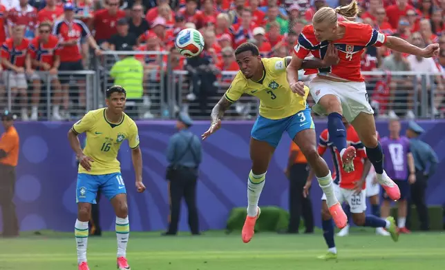 Norway's Erling Haaland (9) shoots and scores their first goal while defended by Brazil's Gabriel Magalhaes (3) during the World Cup round of 16 soccer match between Brazil and Norway in East Rutherford, N.J., near New York, Sunday, July 5, 2026. (AP Photo/Pamela Smith)