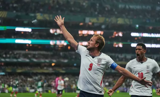 England's Harry Kane (9) celebrates with Jude Bellingham (10) after scoring his side's third goal through penalty kick during the World Cup round of 16 soccer match between Mexico and England in Mexico City, Sunday, July 5, 2026. (AP Photo/Eduardo Verdugo)