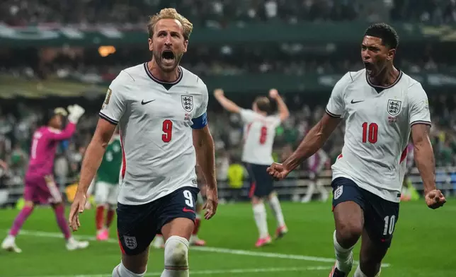 England's Harry Kane (9) celebrates with Jude Bellingham (10) after scoring his side's third goal through penalty kick during the World Cup round of 16 soccer match between Mexico and England in Mexico City, Sunday, July 5, 2026. (AP Photo/Eduardo Verdugo)