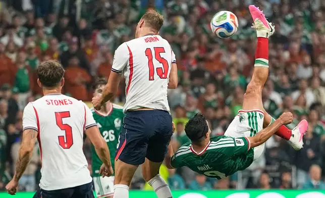 Mexico's Raul Jimenez (9) attempts an overhead kick at goal as England's Dan Burn (15) defends during the World Cup round of 16 soccer match between Mexico and England in Mexico City, Sunday, July 5, 2026. (AP Photo/Natacha Pisarenko)