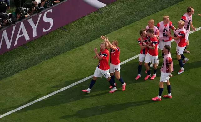 Norway’s Andreas Schjelderup (21) crowns Erling Haaland (9) as others celebrate after Haaland scored their second goal during the World Cup round of 16 soccer match between Brazil and Norway in East Rutherford, N.J., near New York, Sunday, July 5, 2026. (AP Photo/Matt Slocum)