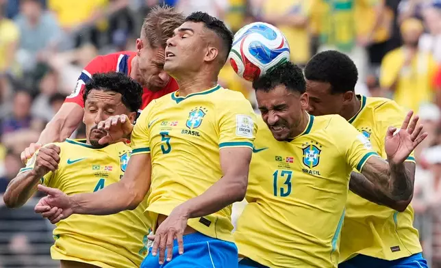 Brazil's Danilo (13) heads the ball near Brazil's Casemiro, center, and Brazil's Gabriel Magalhaes, right, during the World Cup round of 16 soccer match between Brazil and Norway in East Rutherford, N.J., near New York, Sunday, July 5, 2026. (AP Photo/Frank Franklin II)