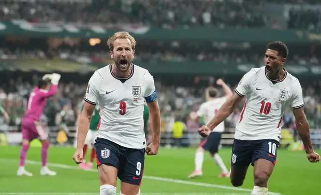 England's Harry Kane (9) celebrates with teammate Jude Bellingham (10) after scoring his side's third goal from penalty kick during the World Cup round of 16 soccer match between Mexico and England in Mexico City, Sunday, July 5, 2026. (AP Photo/Eduardo Verdugo)