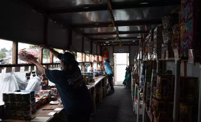 Volunteers Laurene Cardoza, front, and Jennifer Aragon work at a TNT Fireworks stand in Alhambra, Calif., Tuesday, June 30, 2026, ahead of the Fourth of July holiday. (AP Photo/Jae C. Hong)