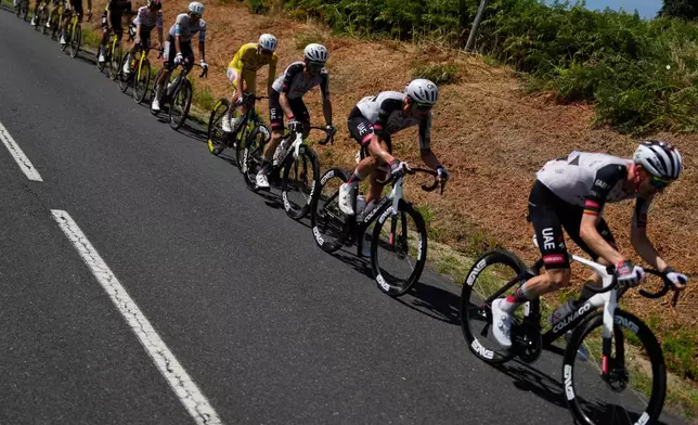 Slovenia's Tadej Pogacar, wearing the overall leader's yellow jersey, rides with the pack during the ninth stage of the Tour de France cycling race with start in Malemort and finish in Ussel, France, Sunday, July 12, 2026. (AP Photo/Mosa'ab Elshamy)