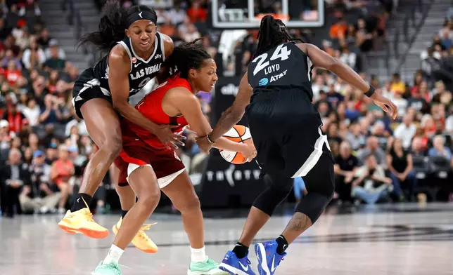 Indiana Fever guard Kelsey Mitchell, center, is fouled by Las Vegas Aces guard Jackie Young, left, as guard Jewell Loyd (24) looks on during the first half of an WNBA basketball game Sunday, July 5, 2026, in Las Vegas. (Steve Marcus/Las Vegas Sun via AP)