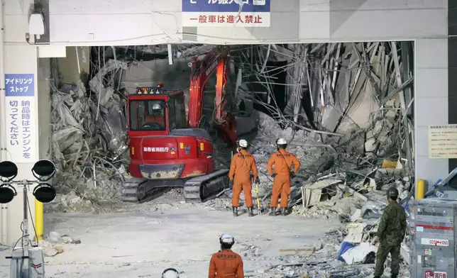 Heavy machinery removes debris at AEON Mall, which was damaged by an explosion following an earthquake, in Kashima, Kumamoto Prefecture, southern Japan, Friday, July 31, 2026. (Kyodo News via AP)