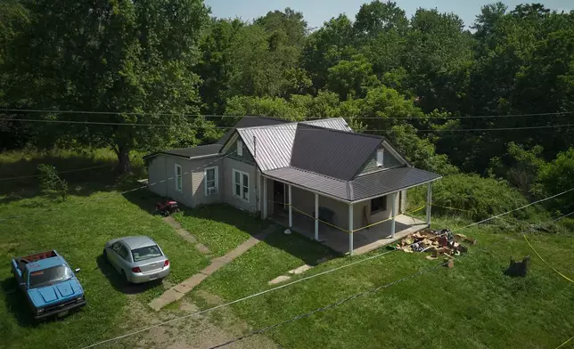 Police tape surrounds a home where authorities say they removed 16 children and arrested four adults in Hamden, Ohio, Wednesday, July 1, 2026. (AP Photo/Carolyn Kaster)