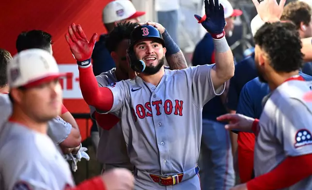 Boston Red Sox's Wilyer Abreu, center, is greeted by teammates after scoring during the fifth inning of a baseball game against the Los Angeles Angels, Saturday, July 4, 2026, in Anaheim, Calif. (AP Photo/William Liang)