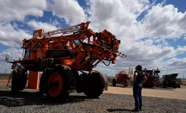 A salesman looks at agricultural machinery displayed at an equipment dealership, representing one of the sectors affected by U.S. tariffs, on the outskirts of Brasilia, Brazil, Wednesday, July 22, 2026. (AP Photo/Eraldo Peres)
