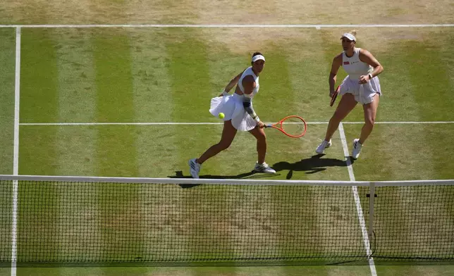 Luisa Stefani of Brazil, left, and Gabriela Dabrowski of Canada eye the ball after returning it to Guo Hanyu of China and Kristina Mladenovic of France in the women's doubles final at Wimbledon Tennis Championships in London, Sunday, July 12, 2026. (AP Photo/Kirsty Wigglesworth)
