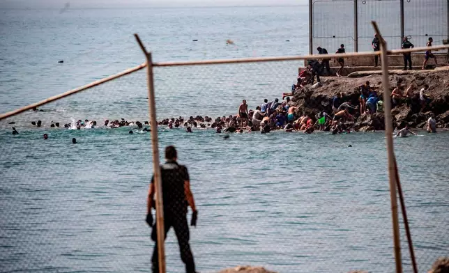 Migrants cross from Morocco into the Spanish enclave of Ceuta, Thursday, July 30, 2026. (AP Photo/Antonio Sempere)