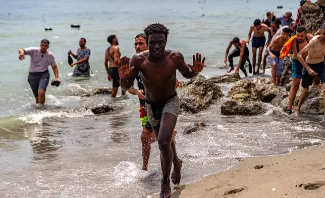 Migrants cross from Morocco into the Spanish enclave of Ceuta, Thursday, July 30, 2026. (AP Photo/Antonio Sempere)