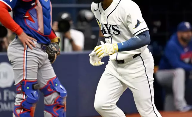 Texas Rangers catcher Austin Wynns looks away as Tampa Bay Rays' Cedric Mullins crosses home plate after hitting a home run during the eighth inning of a baseball game Thursday, July 30, 2026, in St. Petersburg, Fla. (AP Photo/Jason Behnken)