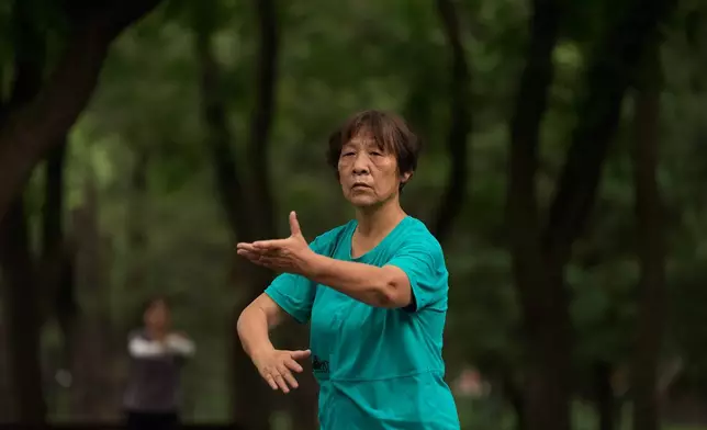 A woman practices Tai Chi at a park near the Temple of Heaven in Beijing, Thursday July 9, 2026. (AP Photo/Andy Wong)