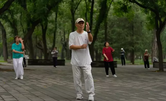 People practice Tai Chi at a park near the Temple of Heaven in Beijing Thursday July 9, 2026. (AP Photo/Andy Wong)