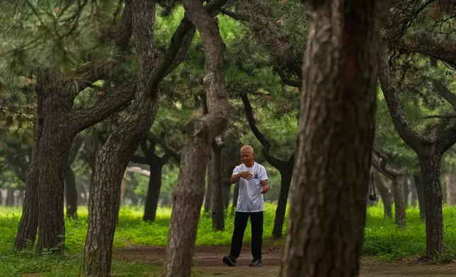 A man practices Tai Chi alone at a park near the Temple of Heaven in Beijing, Thursday July 9, 2026. (AP Photo/Andy Wong)