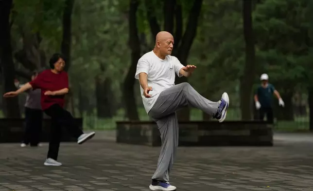 People practice Tai Chi at a park near the Temple of Heaven in Beijing, Thursday July 9, 2026. (AP Photo/Andy Wong)