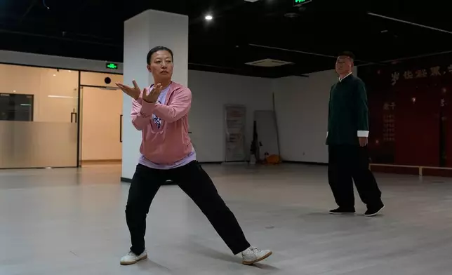 Chen Haitao, right, the 12th generation inheritor of Chen-style Tai Chi watches his student performs Tai Chi at a class in Beijing, Saturday July 11, 2026. (AP Photo/Andy Wong)