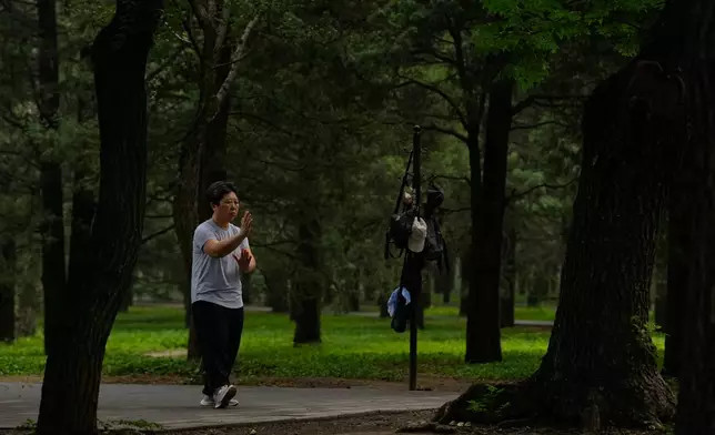 A woman practices Tai Chi at a park near the Temple of Heaven in Beijing, Thursday July 9, 2026. (AP Photo/Andy Wong)