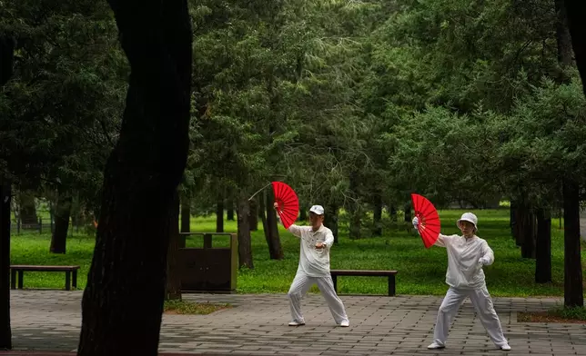 An elderly couple practice Tai Chi at a park near the Temple of Heaven in Beijing, Thursday July 9, 2026. (AP Photo/Andy Wong)