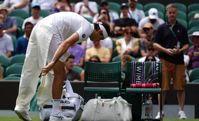 Taylor Fritz of the United States takes off his quick-release trousers as he arrives on court 1 to play against Dusan Lajovic of Serbia in their first round men's singles match at the Wimbledon Tennis Championships in London, Tuesday, June 30, 2026. (AP Photo/Kirsty Wigglesworth)