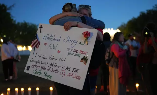 Michelle Whitehead, right, and her sister Judy Whitehead, left, both cousin of victim Ashley Whitehead, during the vigil for victims the day after a shooting at Seattle Center during the Bite of Seattle food festival, Monday, July 27, 2026, in Seattle. (AP Photo/Lindsey Wasson)
