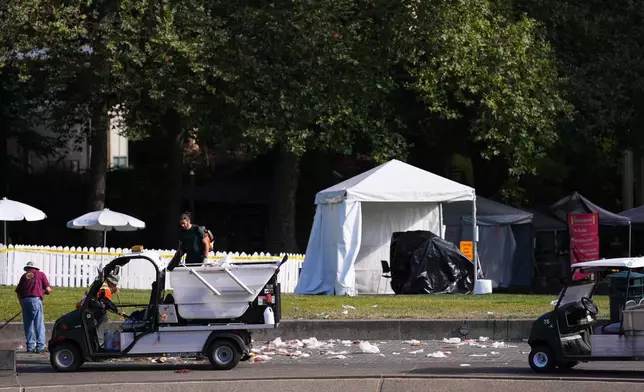 Workers clean up the day after a shooting at Seattle Center during the Bite of Seattle food festival, Monday, July 27, 2026, in Seattle. (AP Photo/Lindsey Wasson)
