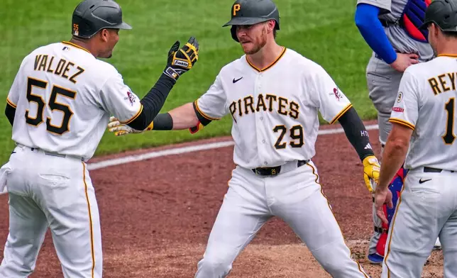 Pittsburgh Pirates' Ryan O'Hearn (29) celebrates with Esmerlyn Valdez (55) and Bryan Reynolds, right, after hitting a grand slam off Chicago Cubs pitcher Jameson Taillon during the third inning of a baseball game in Pittsburgh, Sunday, July 26, 2026. (AP Photo/Gene J. Puskar)