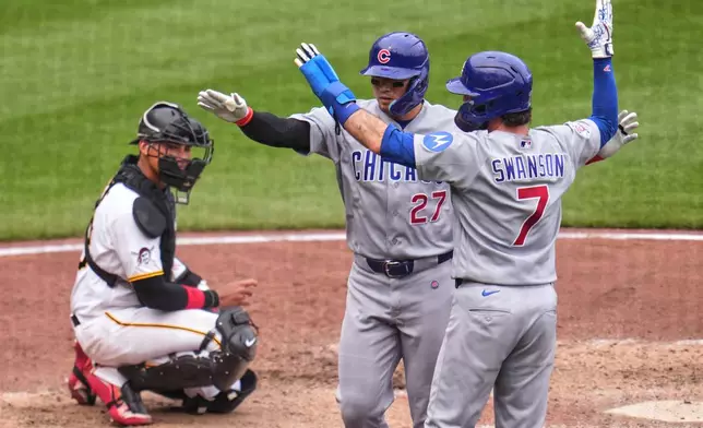 Chicago Cubs' Seiya Suzuki (27) is greeted by Dansby Swanson (7) after hitting a two-run home run off Pittsburgh Pirates pitcher Mason Montgomery as Pirates catcher Shawn Ross, left, looks on during the ninth inning of a baseball game in Pittsburgh, Sunday, July 26, 2026. (AP Photo/Gene J. Puskar)