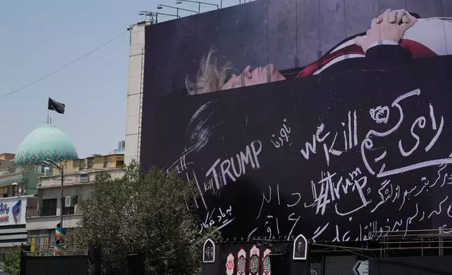 A billboard depicting U.S. President Donald Trump lying on what appears to be a coffin and bearing anti-Trump messages, including the phrase "We Kill Trump," is seen at Islamic Revolution Square in downtown Tehran, Iran, Wednesday, July 15, 2026. (AP Photo/Vahid Salemi)