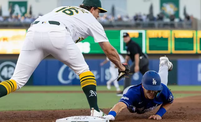 Athletics first baseman Nick Kurtz (16) picks off Los Angeles Dodgers' Tommy Edman during the fifth inning of a baseball game Tuesday, June 30, 2026, in West Sacramento, Calif. (AP Photo/Sara Nevis)