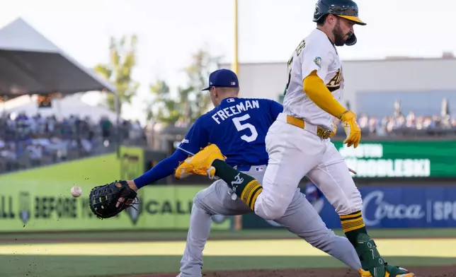 Los Angeles Dodgers first baseman Freddie Freeman (5) attempts to force out Athletics' Shea Langeliers at during the first inning of a baseball game Tuesday, June 30, 2026, in West Sacramento, Calif. (AP Photo/Sara Nevis)