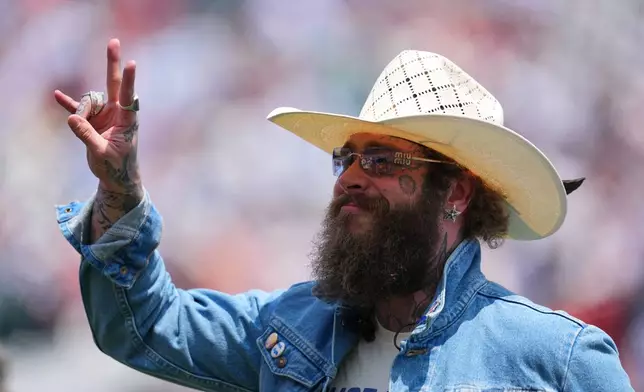 Post Malone waves during the pregame closing ceremony before the World Cup final soccer match between Spain and Argentina in East Rutherford, N.J., near New York, Sunday, July 19, 2026. (AP Photo/Julio Cortez)