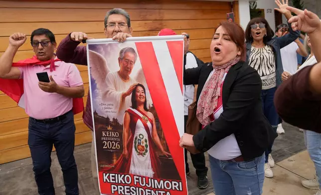 Supporters of President-elect Keiko Fujimori, cheer holding a poster depicting her with her father, former President Alberto Fujimori, outside of her home in Lima, Peru, Friday, July 3, 2026. (AP Photo/Martin Mejia)
