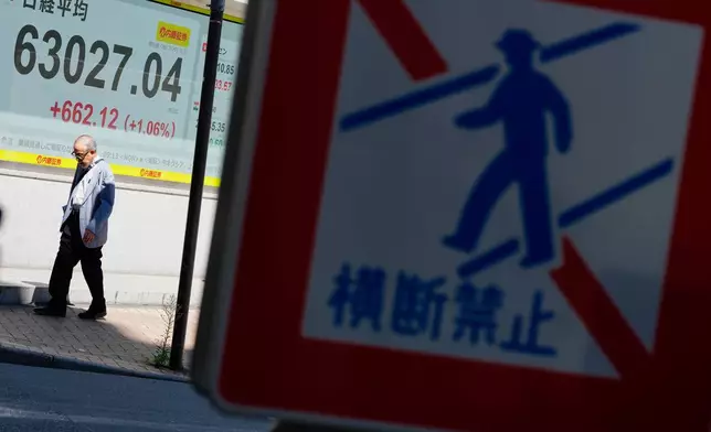 A person walks past an electronic board showing Japan's Nikkei index at a securities firm Wednesday, July 29, 2026, in Tokyo. (AP Photo/Eugene Hoshiko)