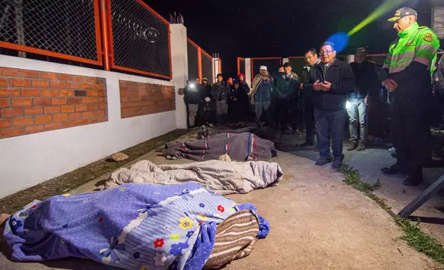Residents stand next to the covered bodies of neighbors who were killed after an earthquake struck Pumpuya, Peru, Sunday, July 19, 2026. ( AP Photo/Javier Ninanya)
