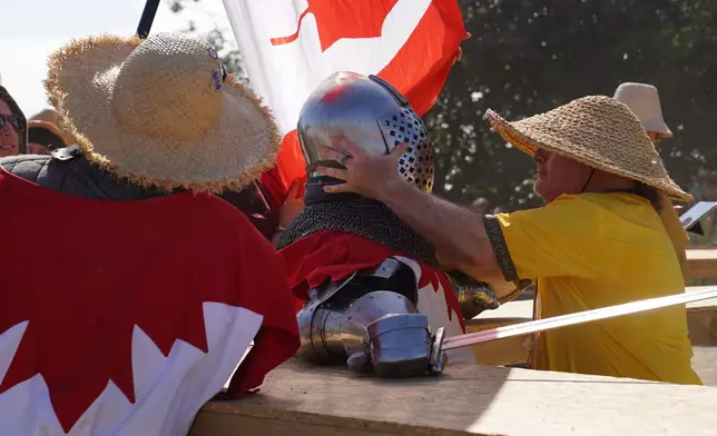 A marshal checks a fighter following a battle at the International Medieval Combat Federation's World Championship at Spottrup Castle, in Spottrup, Denmark, Thursday, July 23, 2026. (AP Photo/James Brooks)