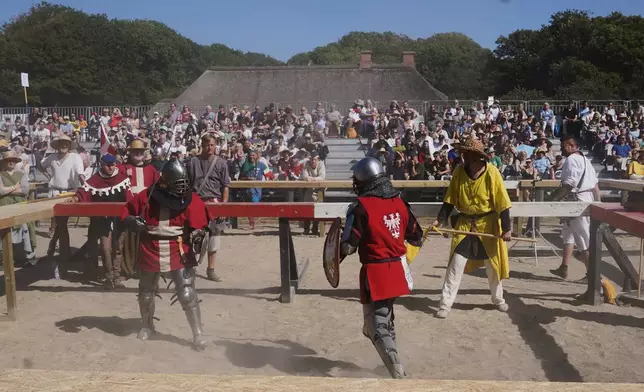 Two fighters battle during the International Medieval Combat Federation's World Championship at Spottrup Castle, in Spottrup, Denmark, Thursday, July 23, 2026. (AP Photo/James Brooks)