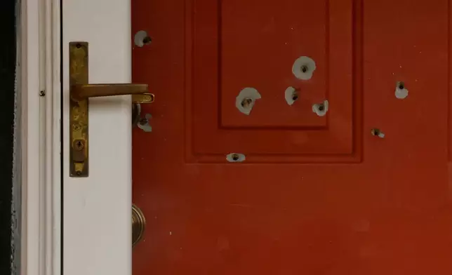 FILE - Bullet holes mark the front door of the house of Minnesota state Sen. John Hoffman and his wife who were shot earlier in the day on June 14, 2025, in Champlin, Minn. (AP Photo/Bruce Kluckhohn, File)