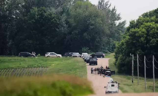 FILE - Members of law enforcement agencies investigate near a vehicle suspected to belong to shooting suspect, Vance Boelter, June 15, 2025, in Belle Plaine, Minn. (AP Photo/George Walker IV, File)
