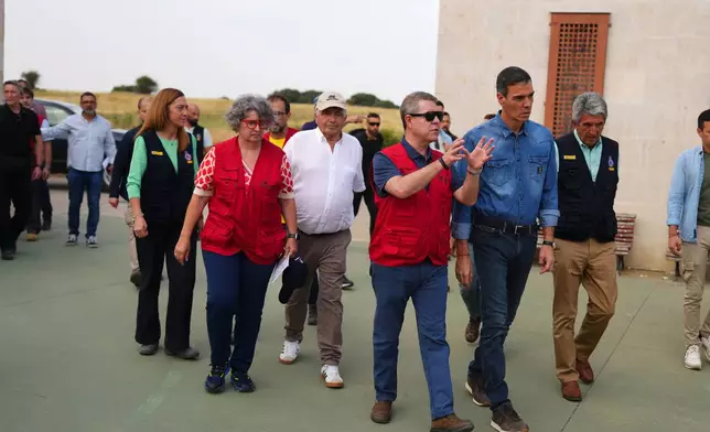Spanish Prime Minister Pedro Sánchez, right, arrives at Tamajón, Guadalajara province, Spain, Wednesday, July 22, 2026, after a wildfire scorched tens of thousands of hectares in one of Spain's largest wildfires in recent years. (AP Photo/Manu Fernandez)