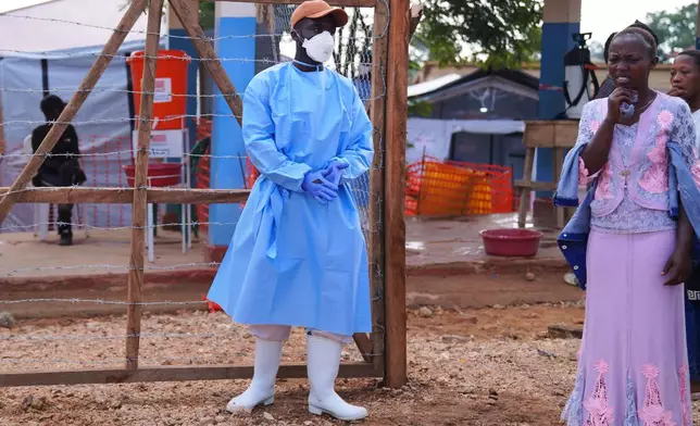 Residence watch as health workers carry a coffin of an Ebola victim at Ebola Treatment Center at Bunia General Hospital in Ituri, Congo, Wednesday, July 22, 2026. (AP Photo/Dirole Lotsima Dieudonne)